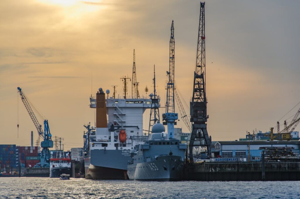 pexels-photo-70418 Cargo port scene with ships and cranes at sunset, showcasing industrial and maritime activity.