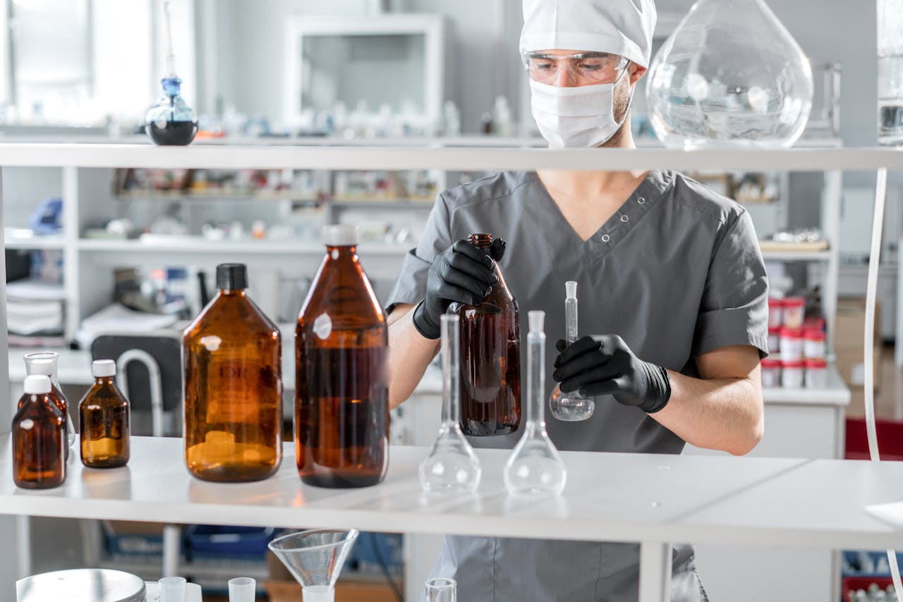 A biochemist wearing safety gear analyzes liquids in a state-of-the-art lab.